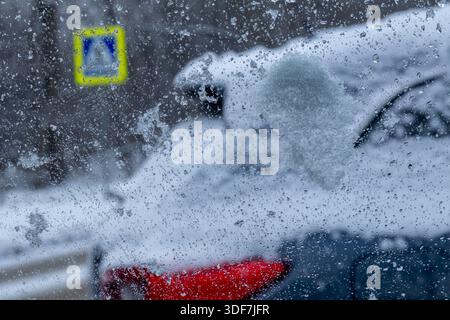 Snow and water droplets on the car window, view from inside the car. Stock Photo