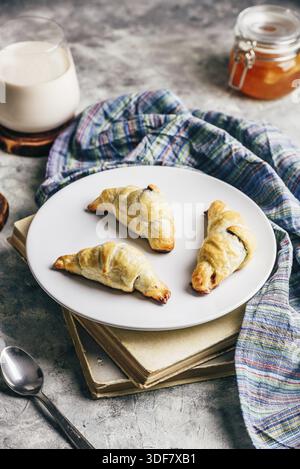 Fresh baked croissants stuffed with nuts and chocolate spread for breakfast Stock Photo