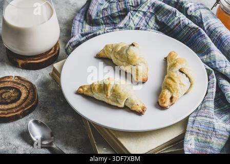 Fresh baked croissants stuffed with nuts and chocolate spread for breakfast Stock Photo