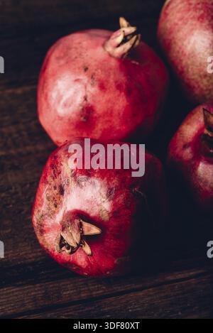 Four ripe pomegranate on rustic wooden table Stock Photo