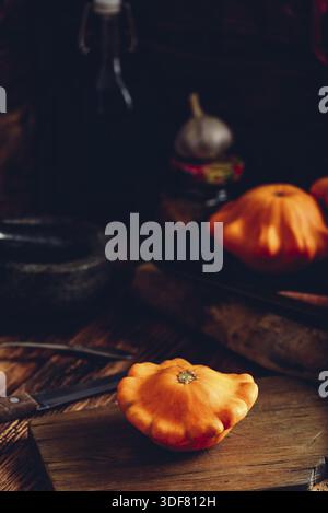 Yellow pattypan squash on cutting board in rustic setting Stock Photo