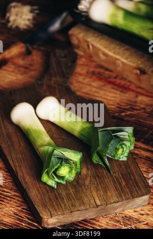 Fresh green leek on wooden cutting board Stock Photo