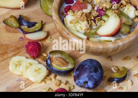 Muesli with berries, fruits and milk - tasty and healthy breakfast. Scattered ingredients and slices of fruits Stock Photo