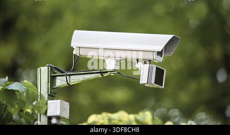Outdoor surveillance video camera on a green background Stock Photo