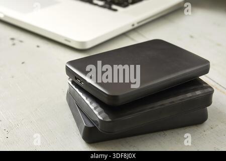 External Hard Disks and Laptop Keyboard on Wooden Table Stock Photo