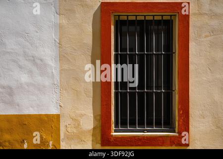 Window with iron bars and painted frame Stock Photo