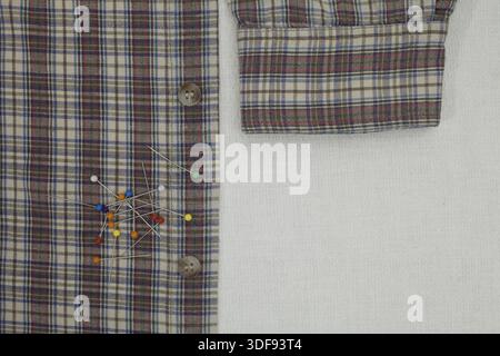 Checkered shirt and pins on a tailor's table, copy space Stock Photo