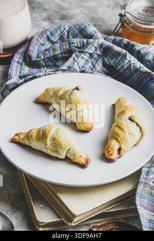 Fresh baked croissants stuffed with nuts and chocolate spread for breakfast Stock Photo