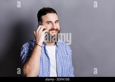 Cheerful bearded man talking on phone Stock Photo
