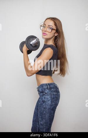 Slim beautiful girl exercising with dumbbell on white background Stock Photo