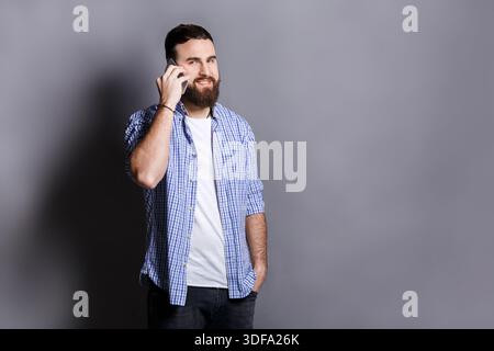Cheerful bearded man talking on phone Stock Photo
