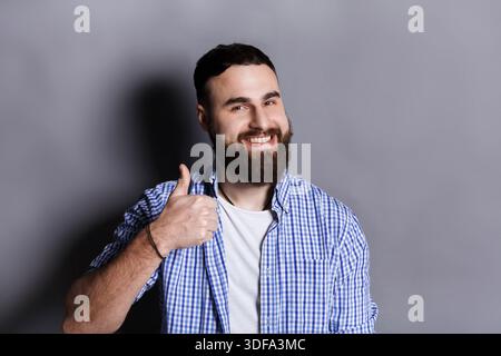 Young hipster man with thumb up portrait Stock Photo