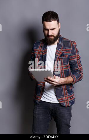 Young bearded man using tablet computer Stock Photo