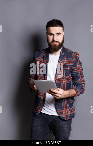 Young bearded man using tablet computer Stock Photo