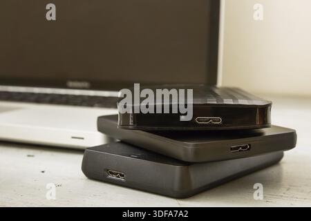 External Hard Disks and Laptop Keyboard on Wooden Table Stock Photo