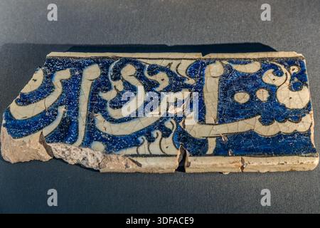 The Karatay Madrasa (Karatay Medresesi) in Konya, Turkey, displays a tile fragment with blue and white glaze, Arabic calligraphy and a diagonal crack through the middle. Seljuk vizier Emir Celaleddin Karatay (d. 1254) had the former Islamic college built in 1251 in the Ferhuniye neighbourhood. Since 1954 the building has served as a tile museum (Konya Tile Works Museum). Stock Photo