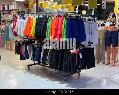 Colorful shorts hanging on a rack in a fashion store. Clothing variety, retail shopping, seasonal apparel, textile display and wardrobe selection. Stock Photo