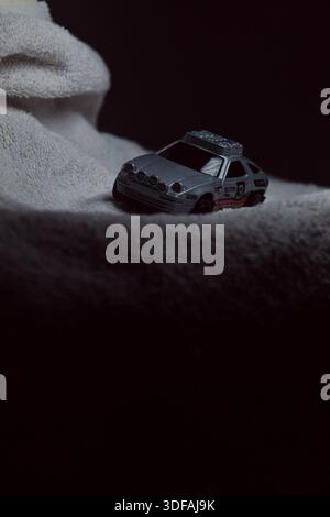 Mantova, Italy - 10TH JANUARY 2025 - Hot Wheels replica of a Porsche 928S Safari in rally livery and trim pretending to run a rally on a snowy road, n Stock Photo