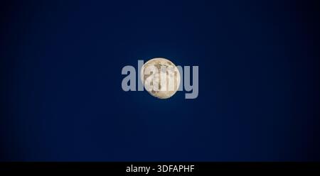 Bright Waxing Gibbous Moon Illuminated Against a Deep Midnight Blue Sky in a Clear and Peaceful Night Stock Photo