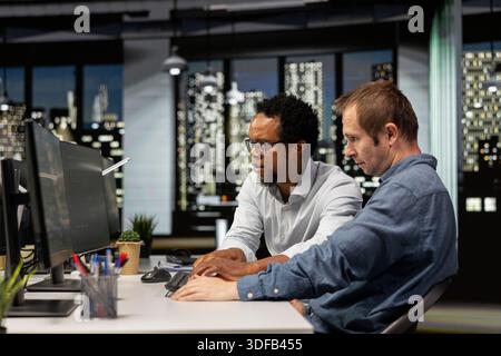 Team of admins coding on PC in startup office, refining machine learning models to enhance automation. Teamworking colleagues using coding platform on computer in technology company workplace Stock Photo