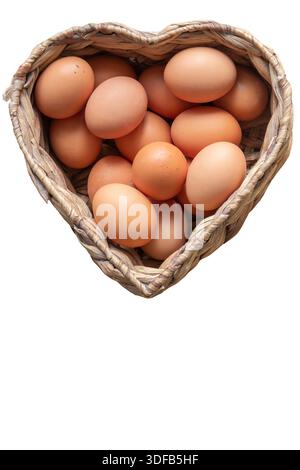 Free range chicken eggs in a heart shaped water hyacinth wicker basket. Isolated on a white background Stock Photo