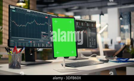 Close up of green screen tablet in brokerage company workplace used for day trading. Stock market portfolio shares on PC display next to chroma key device in proprietary firm office Stock Photo