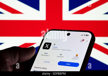 X app shown on Google Play store screen in hand with British flag background, mobile installation view and online safety debate concept. Stafford, Uni Stock Photo