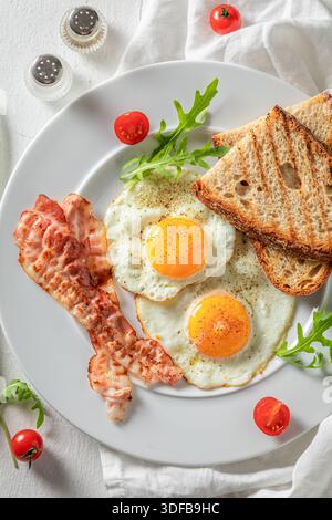 Fresh toasted sandwich with bacon, egg and vegetables. Sandwich with eggs and bacon. Stock Photo