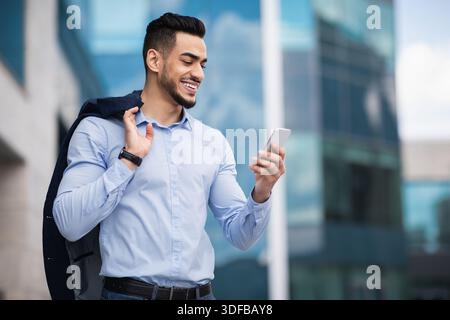 Middle-eastern young entrepreneur checking emails on smartphone Stock Photo