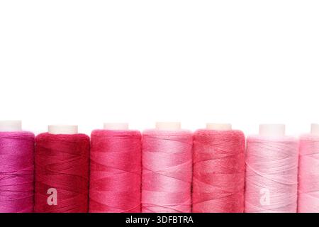 Spools of pink thread on white background Stock Photo