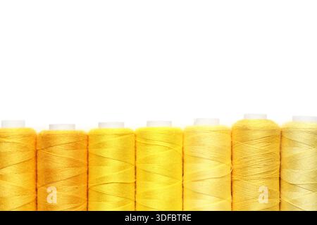 Spools of yellow thread on white background Stock Photo