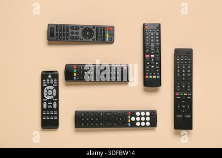 Different modern TV remote controls on beige background Stock Photo