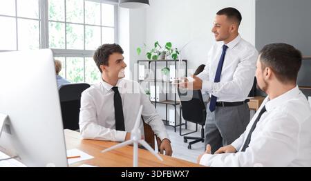 Male engineers working with wind turbine model in office Stock Photo
