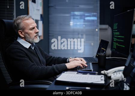 Middle Aged Caucasian Man Working on Computer in Modern Office at Night Stock Photo