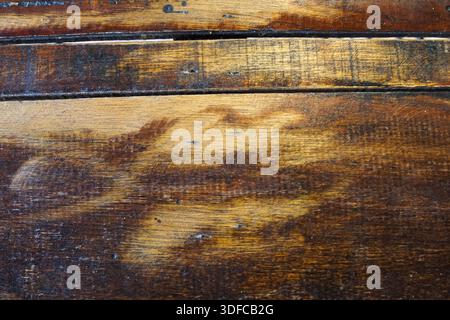 Close-up of weathered dark wood planks with rich grain, scratches, and natural imperfections for design or background use. Stock Photo