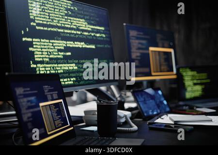 Multiple Computer Monitors Displaying Programming Code in Modern Office Setting Stock Photo
