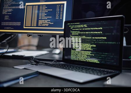 Closeup of Laptop Displaying Programming Code on Desk in Modern Office Stock Photo