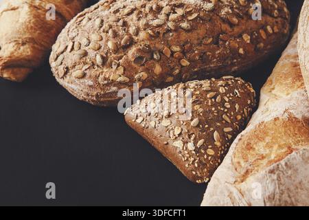 Artisan Bread Selection With Variety of Textures and Seeds Displayed on a Dark Background Stock Photo