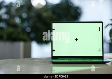Laptop Computer Featuring Green Screen with Tracking Crosses on Table Indoors Stock Photo