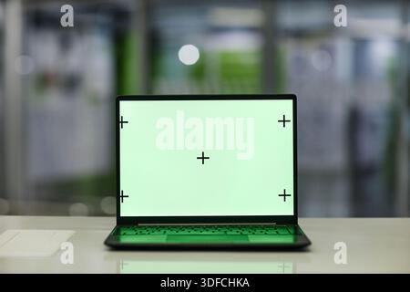 Modern Laptop Computer Displaying Blank Green Screen with Calibration Marks Stock Photo