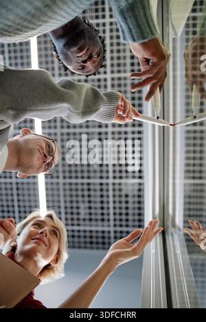 Diverse Adults Collaborating on Project Discussing Data on Office Glass Board  Stock Photo