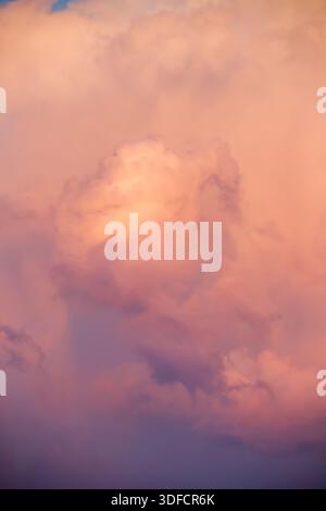 A close-up, abstract-style shot of soft pink and purple clouds blending into the twilight sky. Stock Photo