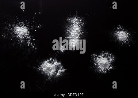 Sprinkled wheat flour splash spots on black background Stock Photo