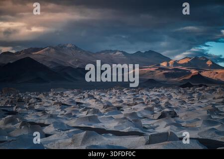 Panoramic view of volcanic rock formations in Catamarca, Argentina. Dramatic storm sky with sunlit mountain peaks. Professional high-resolution landsc Stock Photo