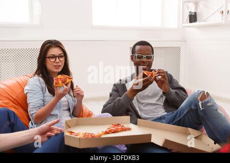 Students sharing pizza at home party Stock Photo