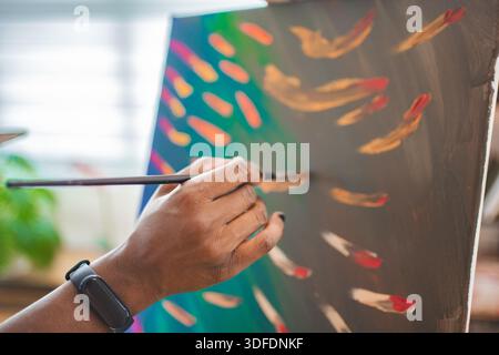 Artist in cozy studio paints vibrant colors Stock Photo