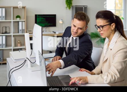 Business team meeting with analytics on monitor, discussing strategy at computer Stock Photo