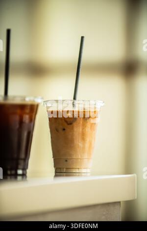Iced coffee and latte coffee served over ice in clear takeaway cups. Classic cafe beverages photographed on a clean, minimal studio background. Stock Photo
