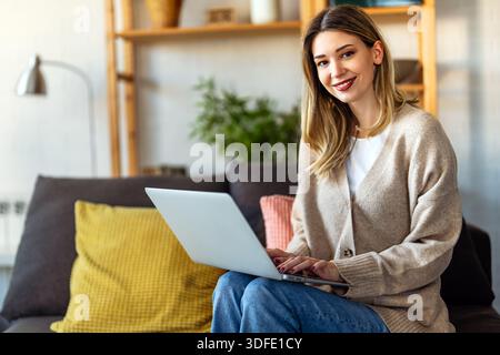 Young female designer, freelancer working in the office. Female using laptop to searching info. Stock Photo