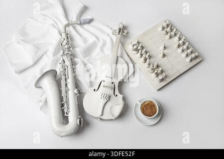 Saxophone, violin, chess and cup of coffee on a white background Stock Photo